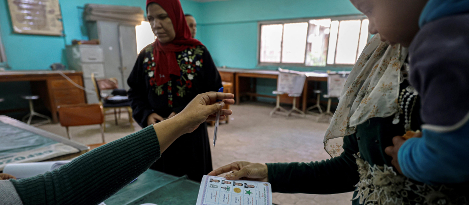 Una mujer egipcia se prepara para emitir su voto en un colegio electoral