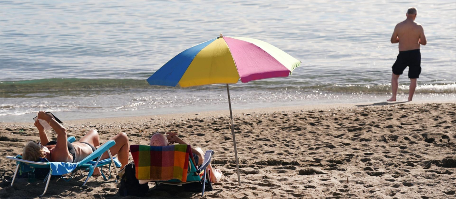 Varias personas disfrutan tomando el sol en la playa de la Malagueta