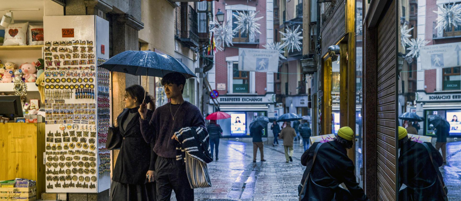 Toledanos y turistas se protegen de la lluvia con paraguas e impermeables para pasear por las calles del casco histórico