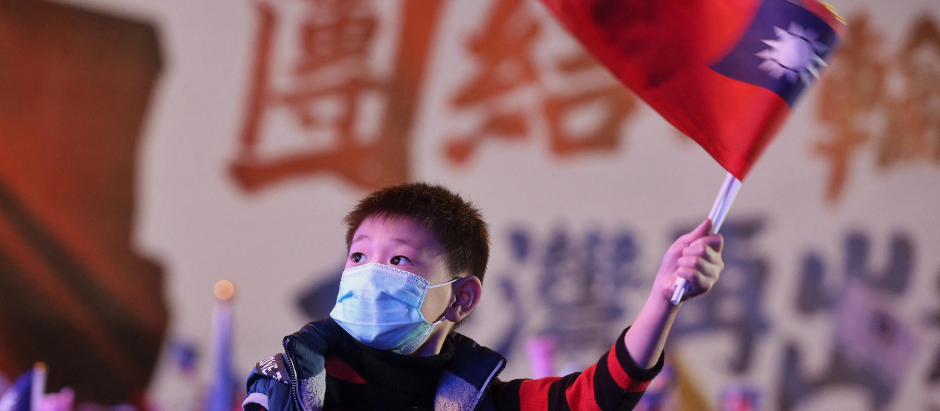 Un niño sostiene una bandera taiwanesa en un acto electoral en Nueva Taipei