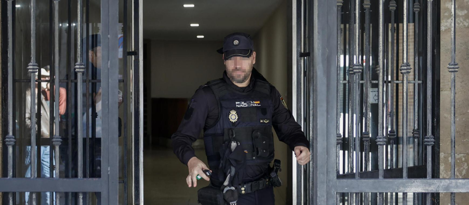 Un agente de la Policía Nacional, este martes, sale de la vivienda del sacerdote asesinado en Valencia