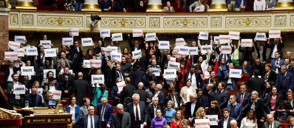 Los parlamentarios de la coalición de izquierda NUPES sostienen carteles contra la ley de inmigración