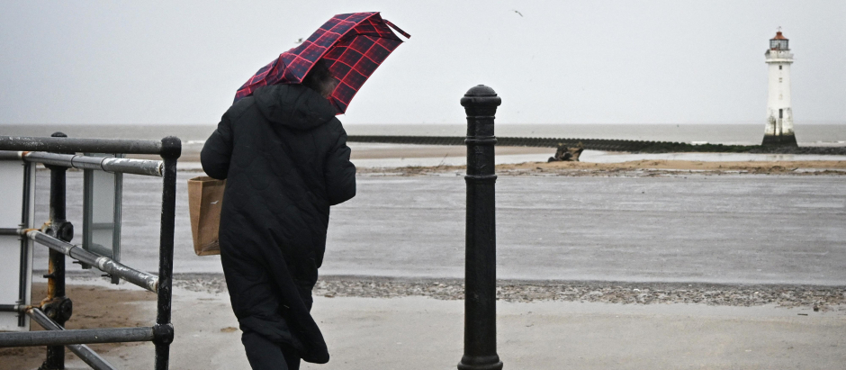 Una persona en New Brighton, Reino Unido, en un temporal de viento y lluvia