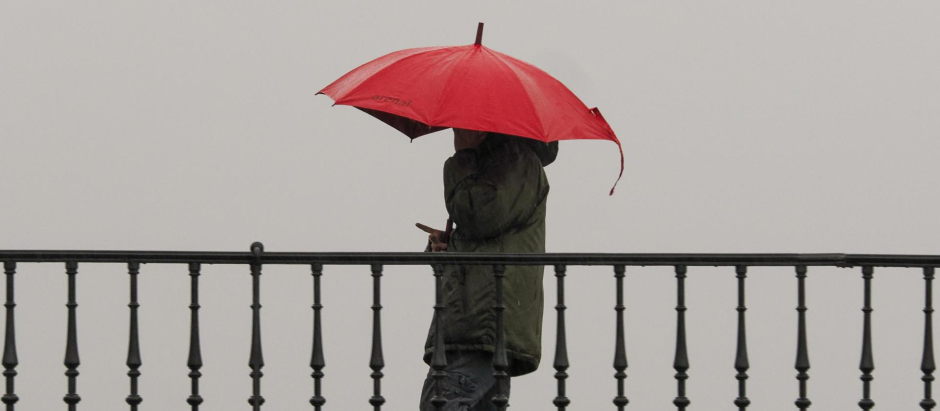 Un hombre camina con paraguas por el Puente de la Misericordia, en Lugo