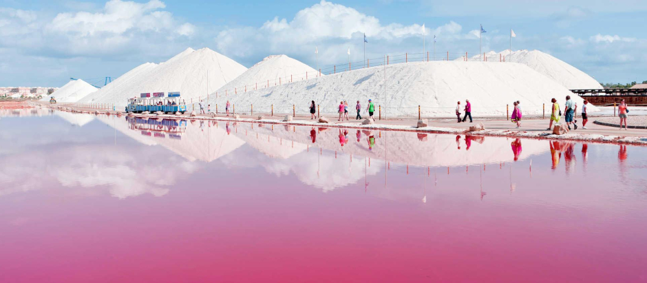Varios turistas caminan junto a la laguna rosa de Torrevieja