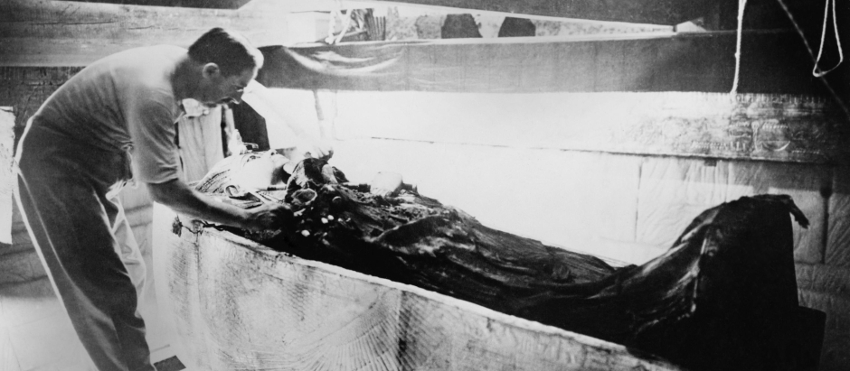 Howard Carter trabaja en la tapa del segundo féretro que aún se encuentra dentro de la caja del primer féretro (el más exterior) en la Cámara Sepulcral