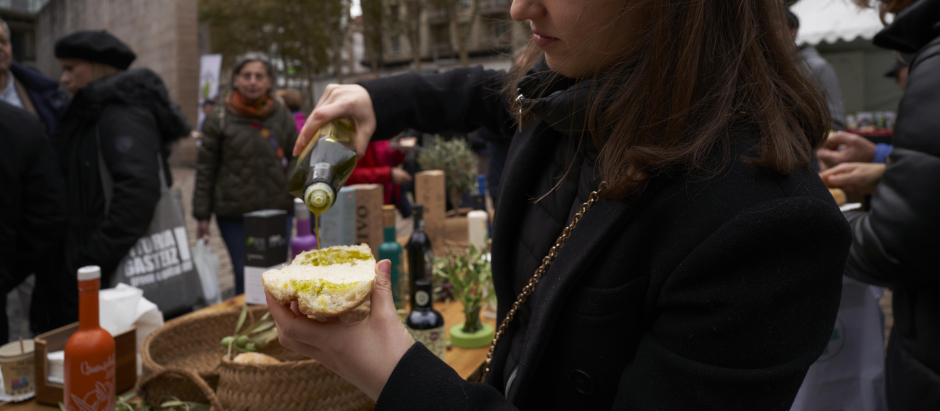 Una mujer rellena una tostada con aceite de oliva de Jaén en una imagen de archivo