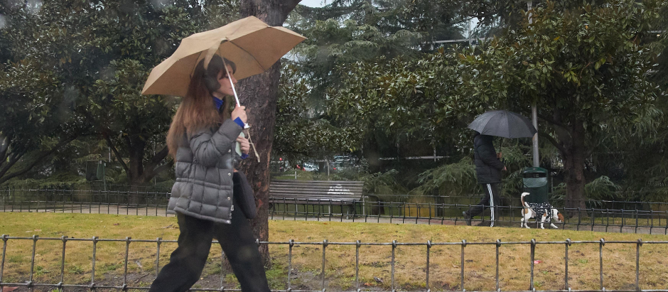 Una mujer se protege de la lluvia en Madrid.