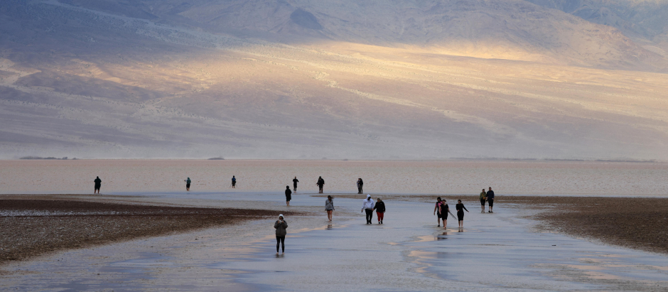 Los turistas disfrutan de la rara oportunidad de caminar en el agua mientras visitan Badwater Basin, el lugar normalmente más seco de EE.UU