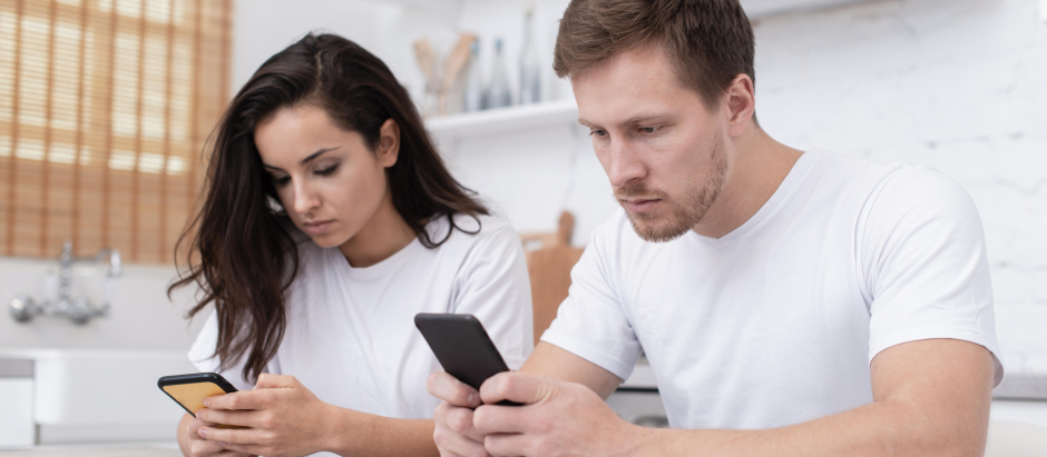 Una pareja con teléfonos móviles sin prestarse atención