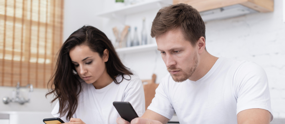 Una pareja con teléfonos móviles sin prestarse atención