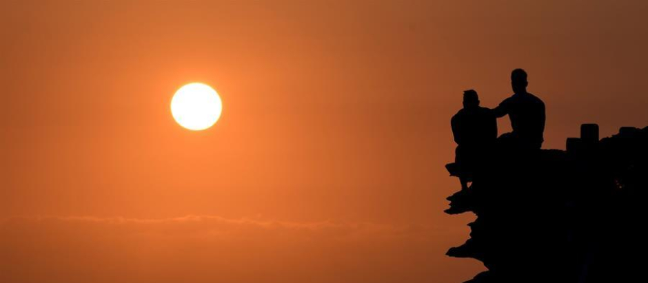 Dos hombres observan el amanecer en Sídney, Australia