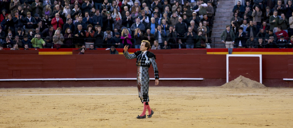 El torero Román Collado saluda al público tras ser embestido por un toro este domingo, durante la Feria de Fallas 2024, en Valencia