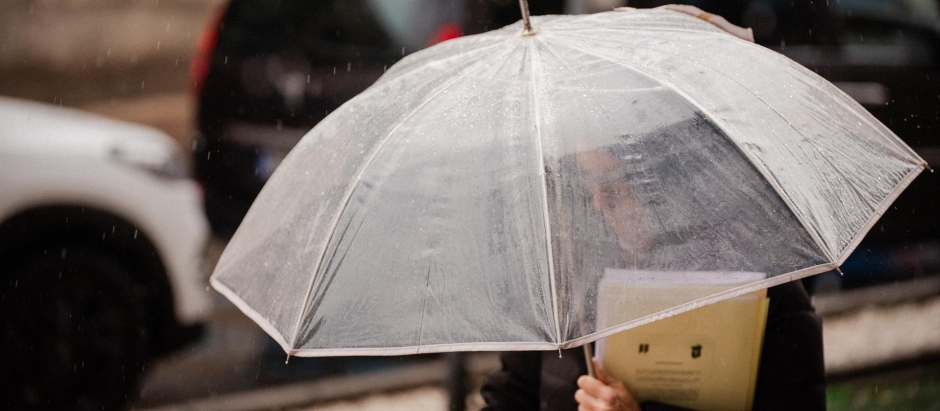 Una persona se protege de la lluvia con paraguas en Madrid
