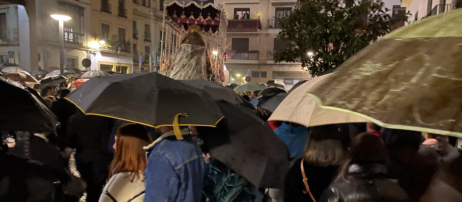 El paso de la Reina de los Ángeles por la calle Capitulares, entre paraguas