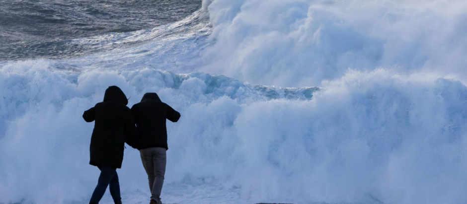 Dos turistas observan el oleaje en la costa de Muxía, este miércoles en A Coruña