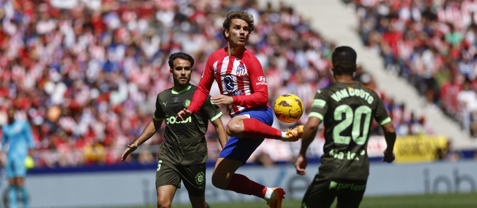 Antoine Griezmann intenta controlar un balón ante los jugadores del Girona