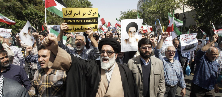 Iraníes gritan consignas y ondean banderas iraníes durante una manifestación antiisraelí en Teherán, Irán