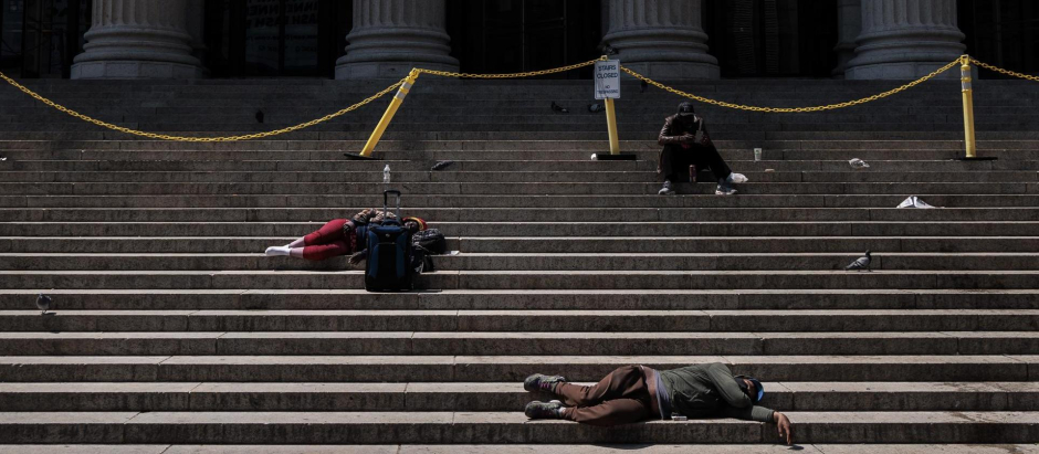 La gente duerme en las escaleras de un edificio de la oficina de correos de los Estados Unidos, en Nueva York