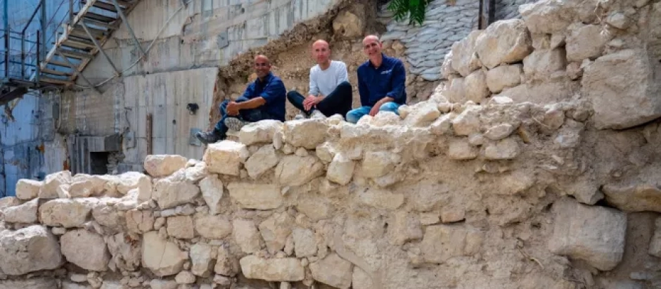 Los directores de la excavación se sientan sobre los restos de la muralla