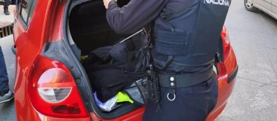 Un agente de la Policía Nacional revisa un coche, este miércoles, en Orriols (Valencia)