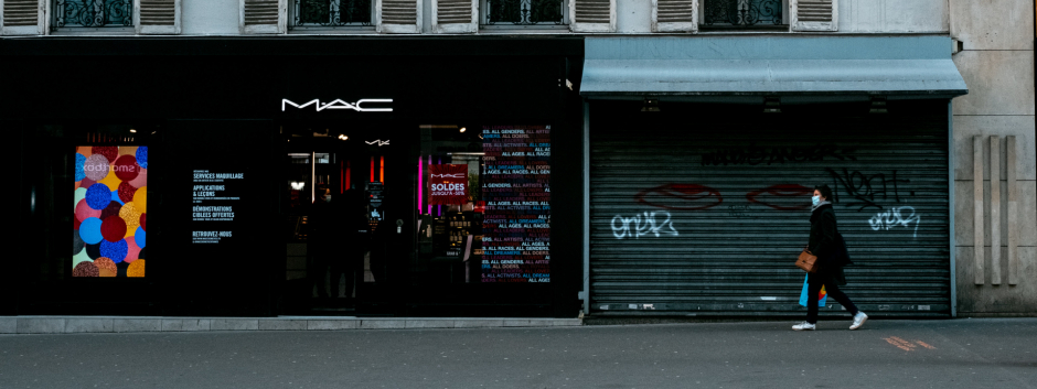 Una mujer camina por la calle delante de un negocio cerrado