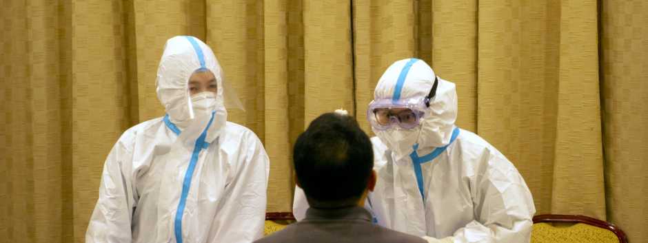 Trabajadores chinos trabajando para la detención de coronavirus