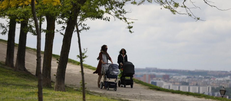 Dos mujeres pasean con sus hijos por el parque