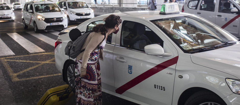 Una pasajera conversa con un taxista en las inmediaciones de la Terminal T4 del Aeropuerto Adolfo Suárez Madrid-Barajas, en una imagen de archivo