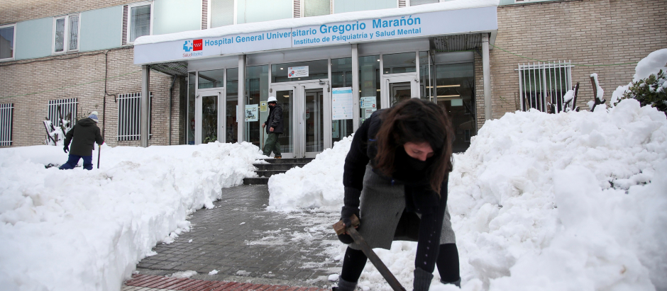 Varios voluntarios despejan con palas el acceso a una de las entradas del Hospital Gregorio Marañon de Madrid
