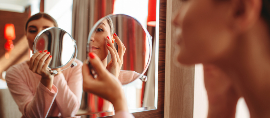 Young woman doing makeup in front of the mirror in the bedroom. Female person cares for skin. Morning face hygiene.the,doing,makeup,mirror,face,hygiene,in,morning, mirror, bedroom, pierglass, beauty, female, indoor, woman, beautiful, looking, face, young, brush, attractive, reflection, home, care, skin, pretty, girl, person, wash, white, happy, smile, routine, people, caucasian, acne, lifestyle, treatment, one, makeup, portrait, healthy, natural, health, hygiene, cosmetics, clean, up, pajama, fresh, touching, body, skincare, freshness, pampering, lady
