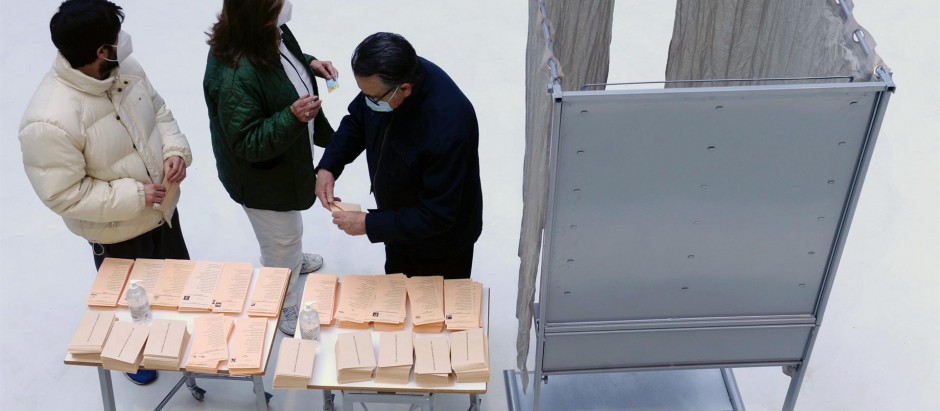 Tres personas preparan su papeleta de votación en un colegio electoral de Valladolid