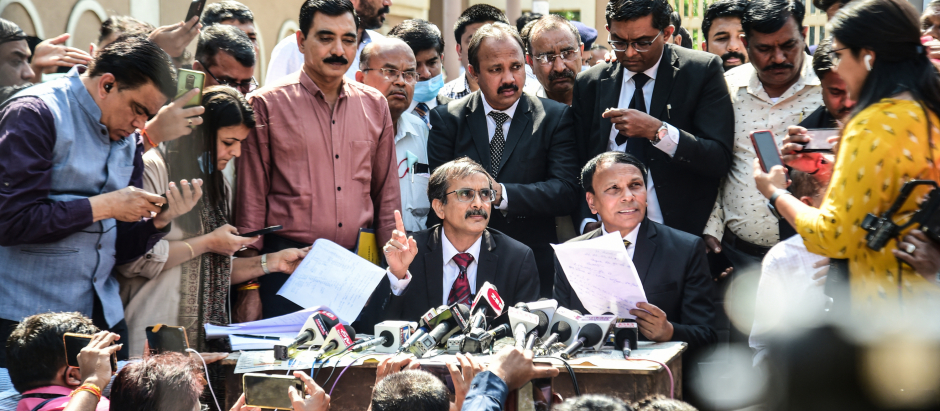 Public prosecutors A R Patel (C-L) and Sudhir Brahmbhatt (C-R) speak to the media outside the Sessions Court in Ahmedabad on February 18, 2022, after an Indian court sentenced 38 people to death over a string of bomb blasts in 2008 that killed dozens in the city of Ahmedabad. (Photo by SAM PANTHAKY / AFP)