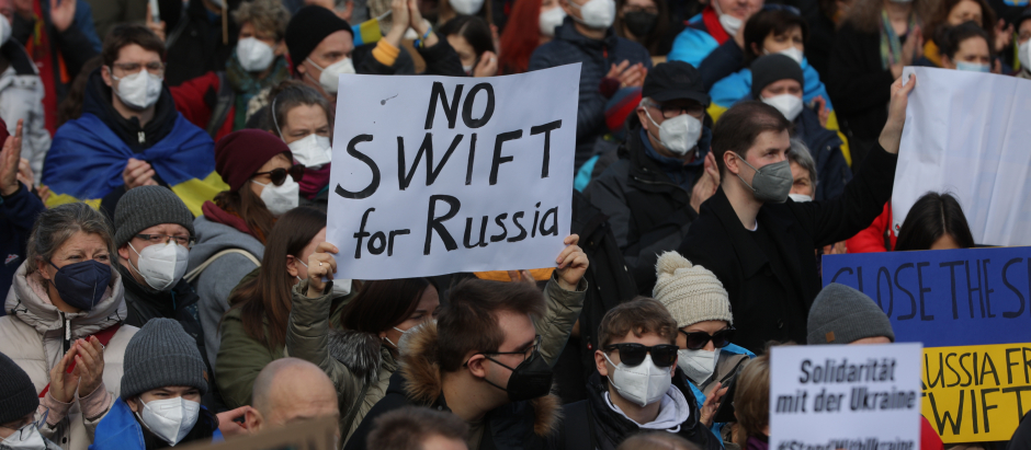 Un manifestante sostiene una pancarta en la que se lee «No al SWIFT para Rusia» durante una manifestación contra la invasión rusa de Ucrania, en Frankfurt