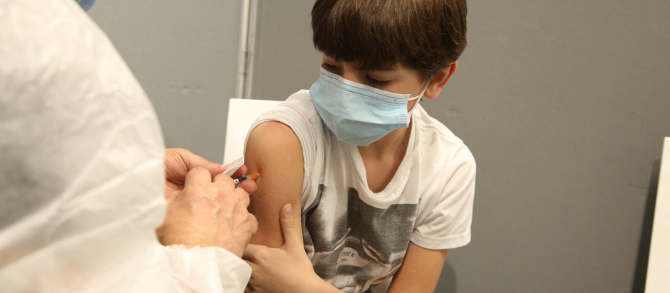 Enfermera vacunando a un niño menor de once años