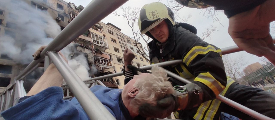 Un sanitario atiende a un hombre herido en un bombardeo, ayer, en Kiev
