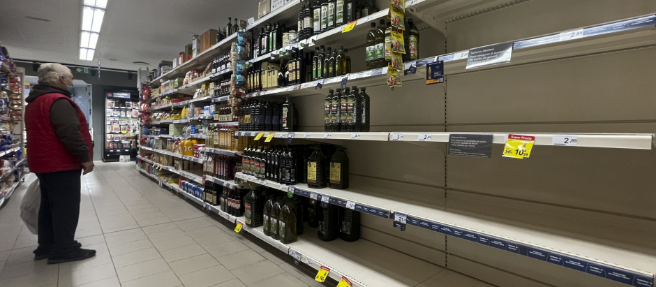 Un hombre observa unas estanterías vacías de aceite en un supermercado de Madrid este sábado