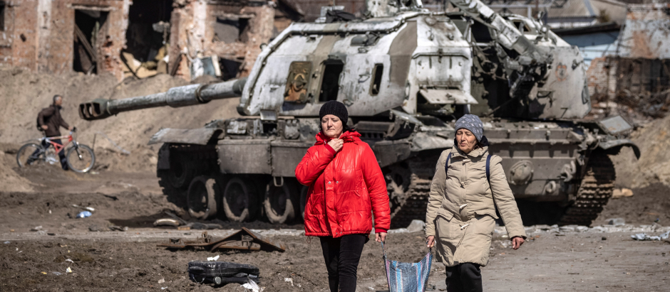 Dos personas caminan junto a un tanque ruso destruido en la ciudad de Trostianets (noreste), este miércoles