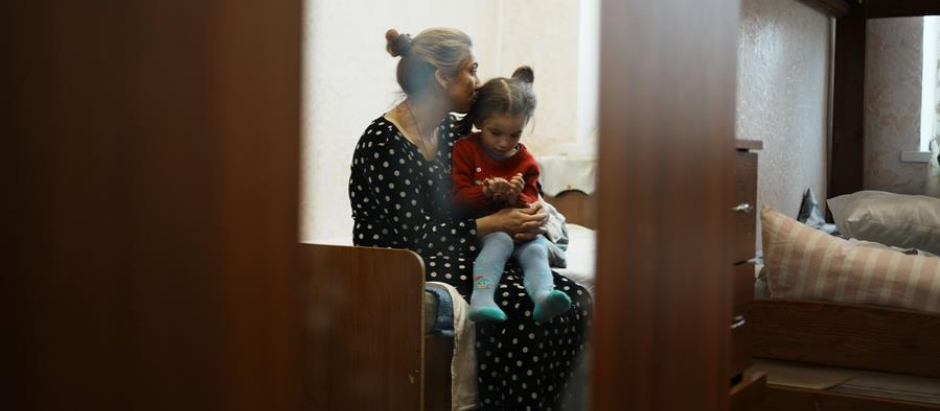 Una refugiada juega con su hija en un piso de Odesa
