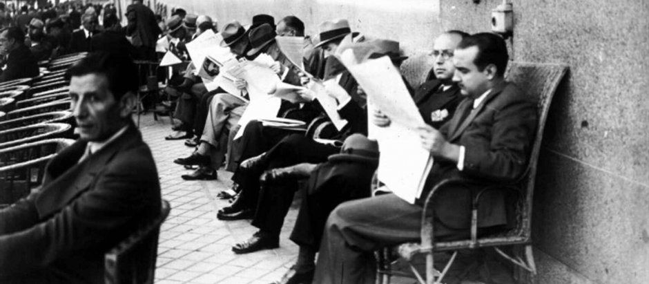 Un grupo de hombres leen el periódico