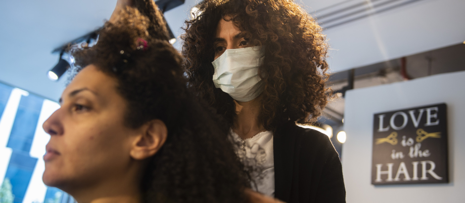 Sara Safwat peina a una mujer egipcia en su peluquería dedicada al pelo rizado en El Cairo