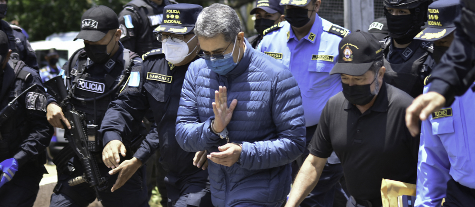 El expresidente de Honduras (de azul celeste) es custodiado durante su extradición a EE.UU.