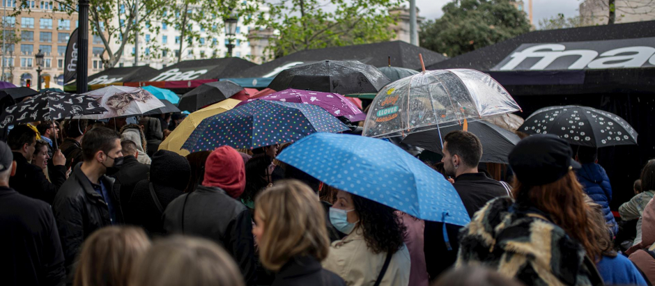 Varias personas, con paraguas, en la feria literaria de Sant Jordi