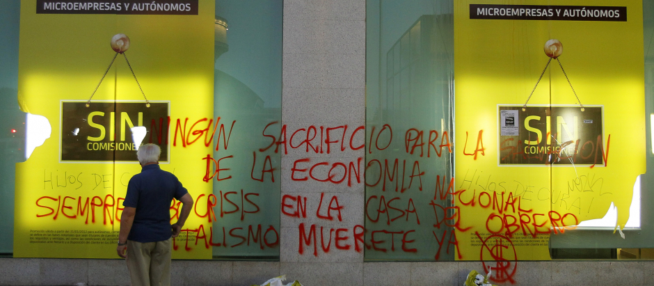 Un hombre camina por un banco de Bankia en plena crisis financiera. Junio de 2012