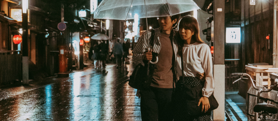 Una pareja de japoneses caminando bajo la lluvia