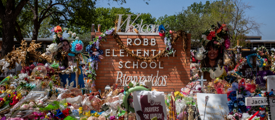 Tributos con flores y obsequios rodean el cartel que marca la entrada a la escuela primaria Robb Elementary