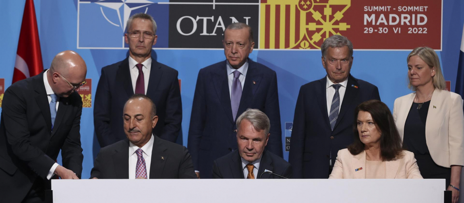 Los ministros de exteriores de Turquía, Mevlüt Çavusoglu; Finlandia, Pekka Haavisto, y Suecia, Ann Linde, firman un acuerdo tras varias horas de reuniones para desbloquear el veto turco