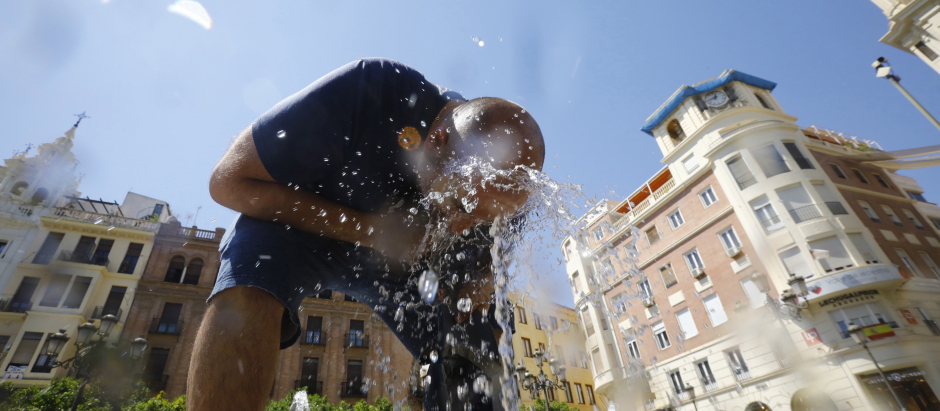 Un hombre se refresca para aliviar el calor en una fuente del centro de Córdoba
