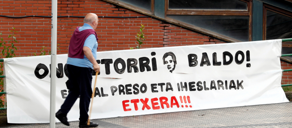 Un hombre pasa junto a una pancarta de bienvenida al histórico dirigente de ETA José Javier Zabaleta Elosegi, "Baldo"