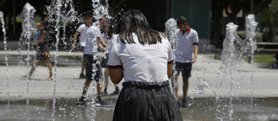 Mujer refrescándose en una fuente para evitar un golpe de calor